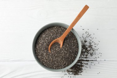 Chia tohumları, ahşap kaşık ve beyaz ahşap arka plan üzerinde kase, kopya