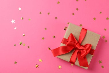 Süslü pembe arka planda fiyonklu hediye kutusu, metin için boşluk