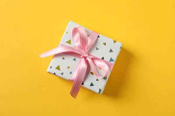 Sarı arkaplanda yay olan hediye kutusu, metin için boşluk — Stok fotoğraf