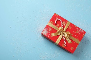 Hediye kutusu, baston şeker ve mavi arka planda kar, üst manzara.