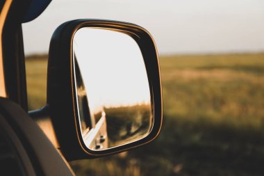 Arabanın aynasında gün batımı. Güzel yaz akşamı havası