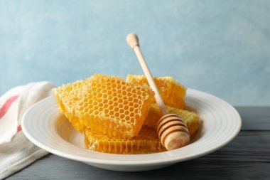 Ahşap zemin üzerinde dipper ve bal peteği tabağı, boşluk