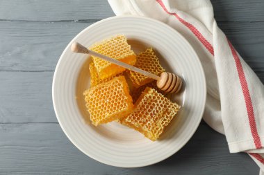 Ahşap zemin üzerinde dipper ve bal peteği tabağı, boşluk