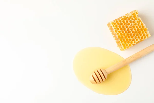 Dipper in puddle of honey and honeycomb on white background, top — Stock Photo, Image