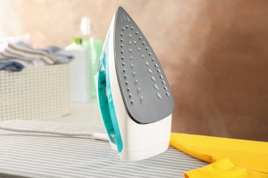 Ütü masasında demir ve sarı tişört, metin için boşluk