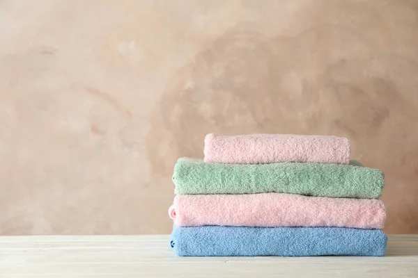 Stack of clean towels against brown background, space for text — Stock Photo, Image