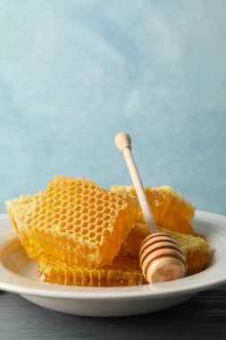 Ahşap zemin üzerinde dipper ve bal peteği tabağı, boşluk