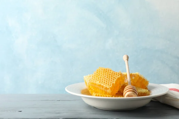 Tallrik med dipper och honeycombs på trä bakgrund, utrymme för — Stockfoto