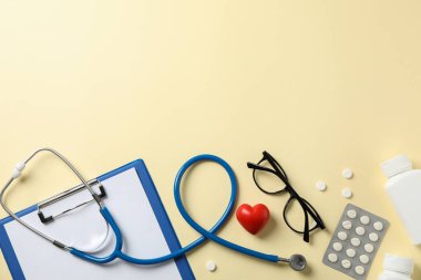 Sarı arka planda steteskop ve ilaçlar. Doktor.