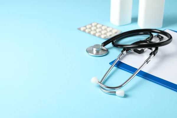 Stethoscope, tablet and medicine on blue background, space for t — Stock Photo, Image