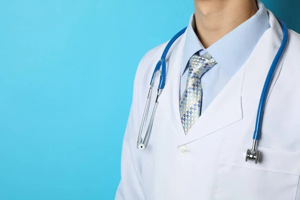 Доктор в медичній сукні зі стетоскопом на синьому фоні , — стокове фото