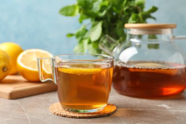 Limonlu çay, gri arkaplanda çaydanlık ve nane, kapat.