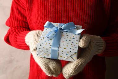 Elinde açık mavi fiyonklu hediye kutusu olan genç bir kadın. Yaklaş.