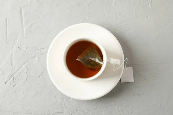 Egy csésze tea tea táska szürke háttér, felső nézet — Stock Fotó