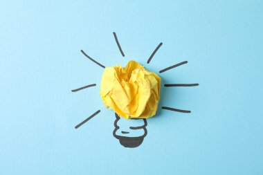 Mavi arka planda ampul ve kağıt top çizildi. İyi fikir.