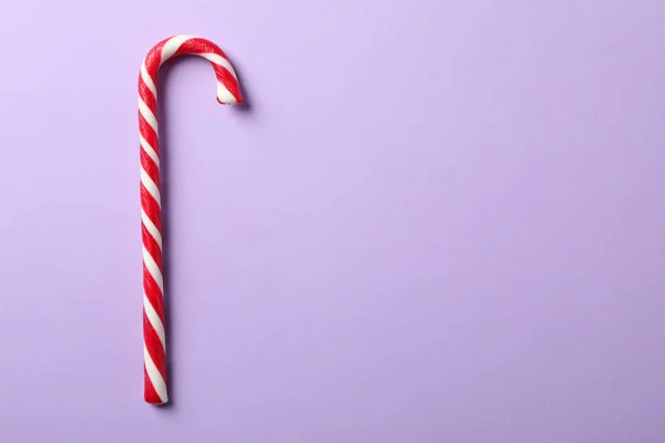 Sweet candy cane on color background, space for text — ストック写真