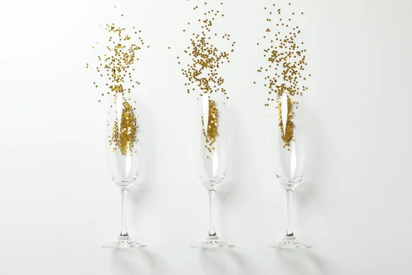 Champagne glasses with glitter on white background, space for te — Stock Photo, Image