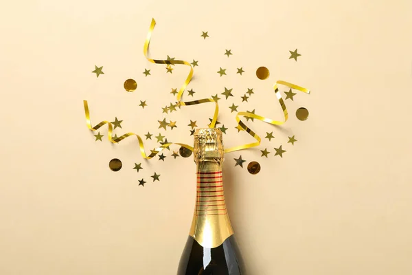 Бутылка шампанского и блеск на бежевом фоне, место для текста — стоковое фото