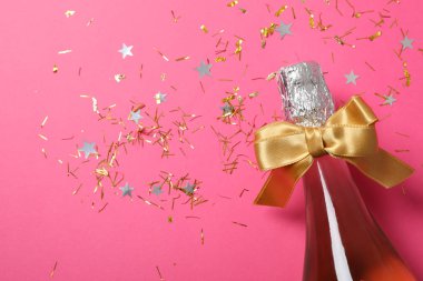 Pembe arka planda fiyonklu şampanya şişesi, kapat. 