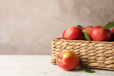 Beyaz ahşap arka planda elmalı sepet, boşluğu kopyala