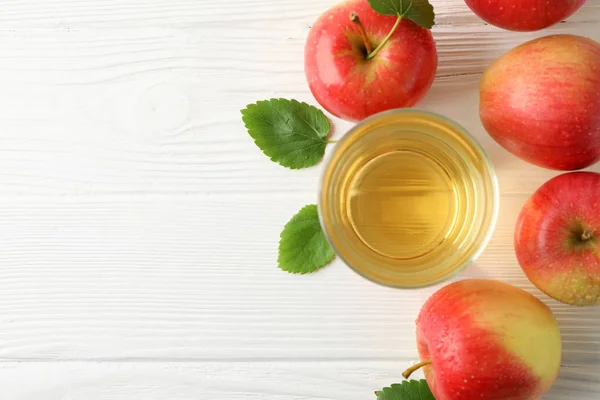 Äpfel und Glas mit Saft auf Holzgrund, Draufsicht — Stockfoto