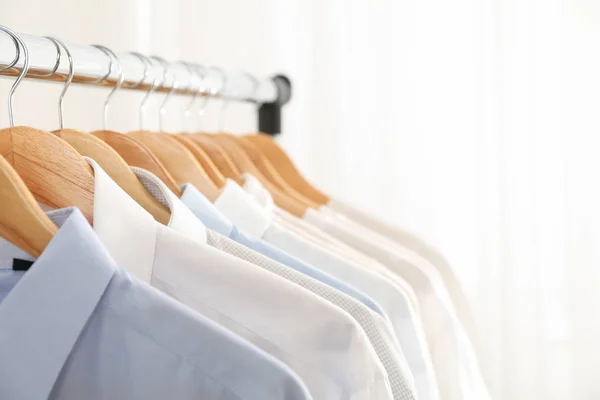 Kleiderbügel mit Hemden vor hellem Hintergrund, Kopierraum — Stockfoto