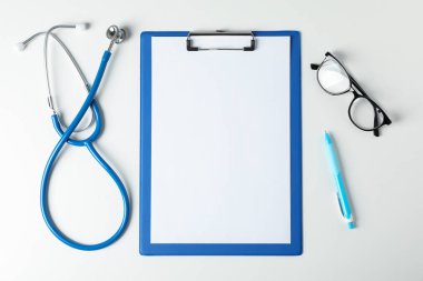 Stetoskop, tablet, gözlük ve kalem mavi arka planda, boşluk f