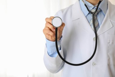 Siyah steteskoplu, tıbbi giysili doktor, mesaj için yer var.