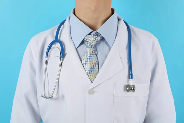 Doutor em vestido médico com estetoscópio contra fundo azul , — Fotografia de Stock