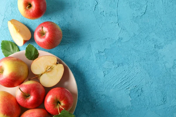 Apples and plate on blue background, space for text — Stock Photo, Image