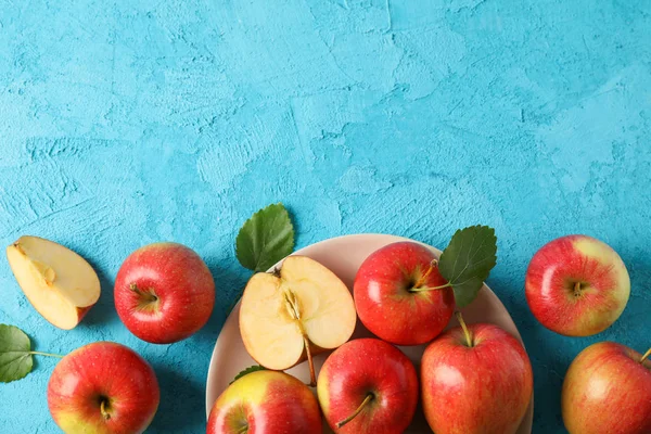 Apples and plate on blue background, space for text — Stock Photo, Image