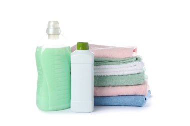 Çamaşır deterjanı ve katlanmış havlular beyaz arkaplanda izole edilmiş.