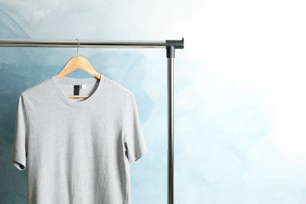 Bastidor con camiseta gris en blanco sobre fondo azul, espacio para texto — Foto de Stock