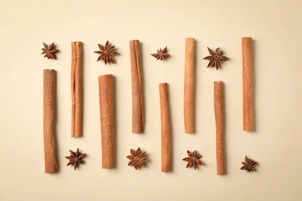 Flat lay with cinnamon sticks and anise stars on beige backgroun — Stock Photo, Image