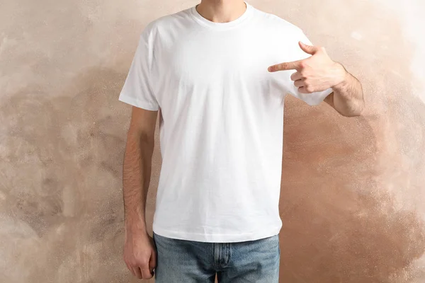 Men in blank white t-shirt against brown background, space for t — Stockfoto