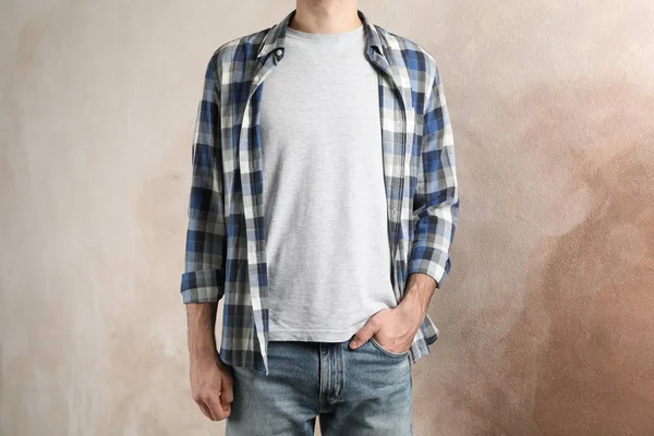 Men in grey t-shirt and checkered shirt against brown background — Φωτογραφία Αρχείου