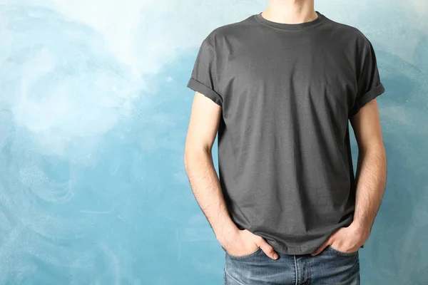 Men in blank grey t-shirt against blue background, space for tex — Stock Photo, Image
