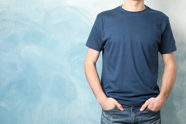 Men in blank blue t-shirt against color background, space for te — Stock fotografie