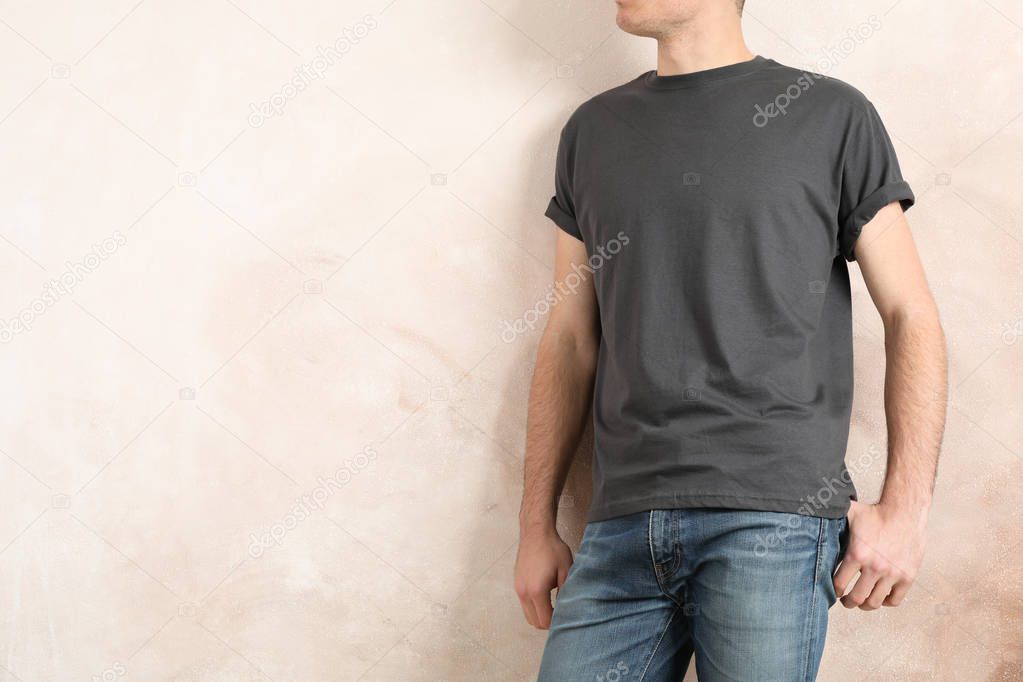 Men in blank grey t-shirt against color background, space for te