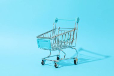 Mavi arka planda küçük alışveriş arabası, metin için boşluk