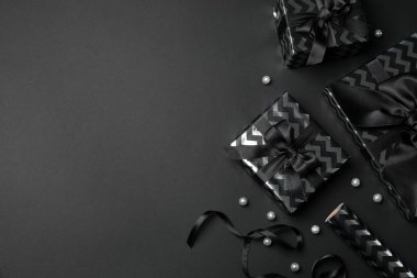 Siyah arka planda fiyonklu hediye kutuları. Kara Cuma indirimi