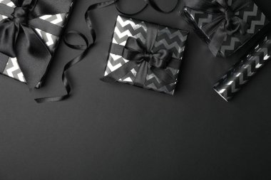 Siyah arka planda fiyonklu hediye kutuları. Kara Cuma indirimi