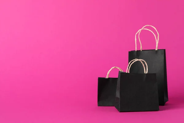 Small paper bags on pink background, space for text — Stock Fotó