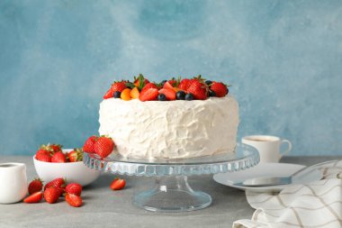 Gri masada lezzetli çilekli pasta ile kompozisyon. Lezzetli tatlı