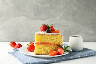 Gri arka planda lezzetli dutlu kremalı pasta kompozisyonu. Lezzetli tatlı