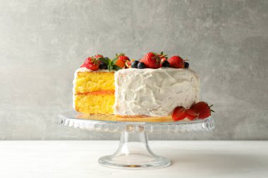 Gri arka planda lezzetli dutlu kremalı pasta kompozisyonu. Lezzetli tatlı