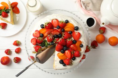 Beyaz ahşap masada lezzetli çilekli pasta kompozisyonu. Lezzetli tatlı