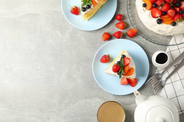 Gri arka planda lezzetli dutlu kremalı pasta kompozisyonu. Lezzetli tatlı