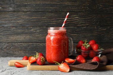 Gri masada çilekli kokteyl kompozisyonu. Yaz meyvesi