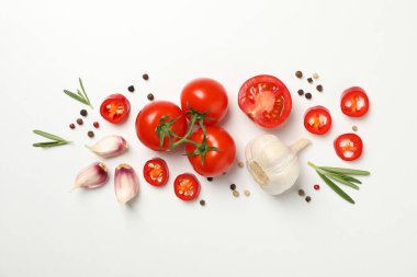 Beyaz arkaplanda domatesler ve malzemeler, üst görünüm